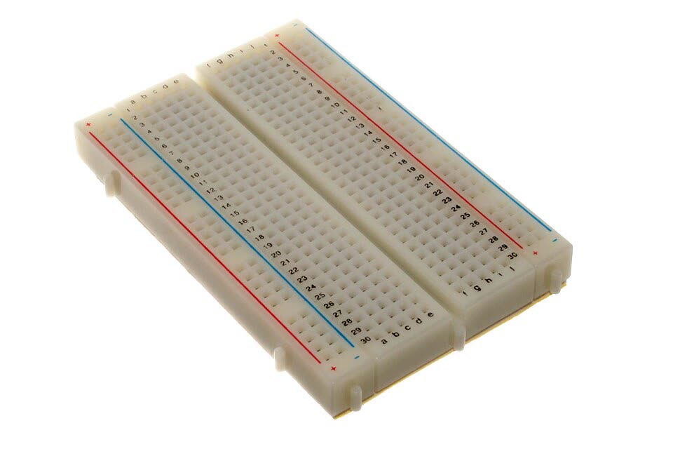 Breadboard putih dengan deretan lubang